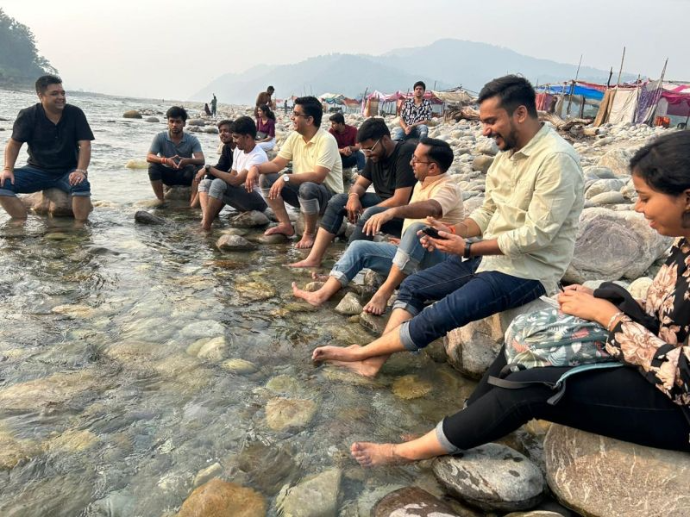 i8CLOUD team enjoying a serene riverside moment at Jim Corbett – blending relaxation and nature during a memorable team getaway.  Would you like me to group t